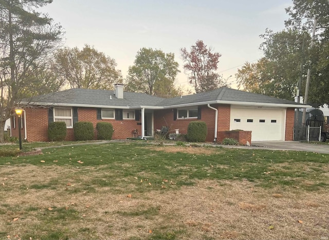 ranch-style home with a yard and a garage