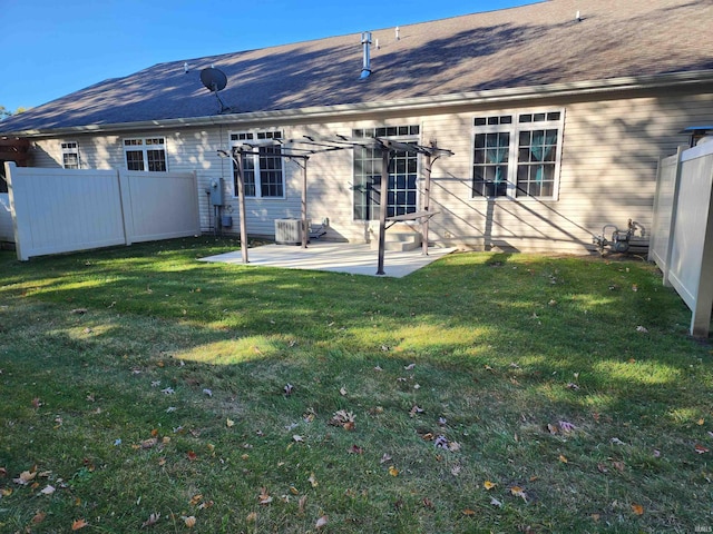 back of house with a patio and a lawn