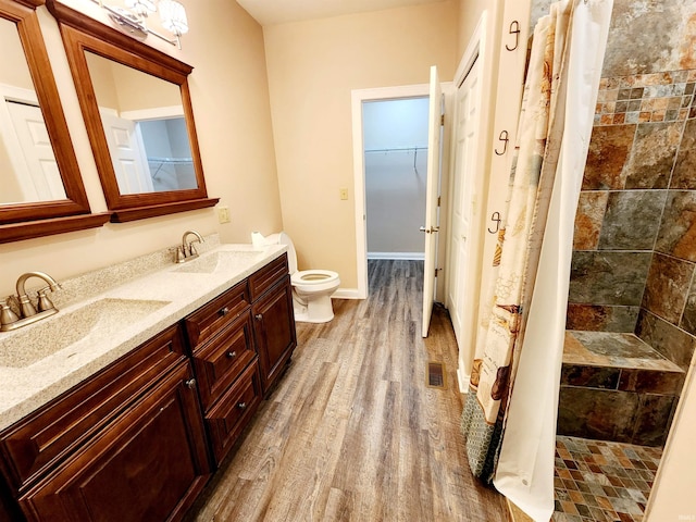 bathroom with vanity, walk in shower, toilet, and wood-type flooring