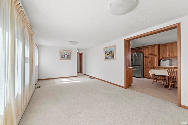 carpeted empty room featuring a textured ceiling