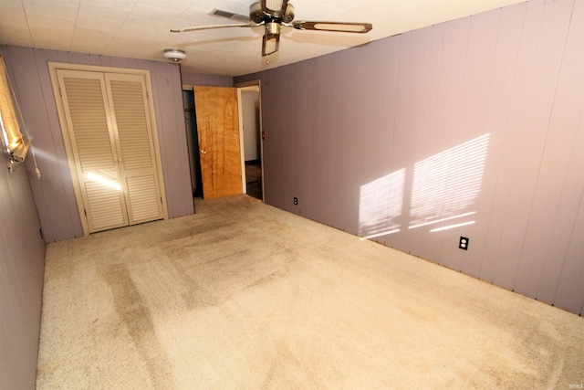 unfurnished bedroom featuring a closet, carpet, and ceiling fan