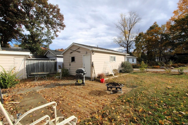 back of property featuring a fire pit and an outdoor structure