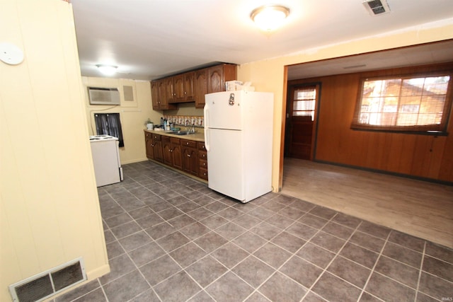 kitchen featuring sink, a wall unit AC, white appliances, dark hardwood / wood-style flooring, and decorative backsplash