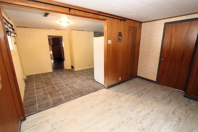 empty room with dark wood-type flooring and wooden walls