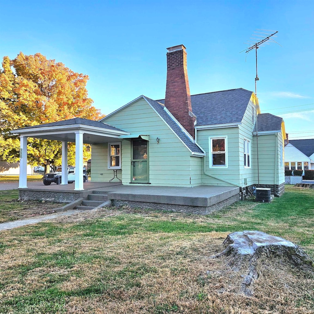 back of property featuring a patio, central air condition unit, and a lawn