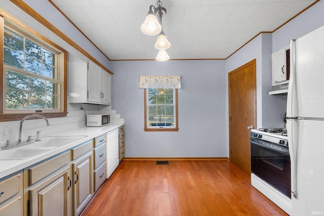 kitchen with light hardwood / wood-style floors, hanging light fixtures, sink, white cabinets, and white appliances