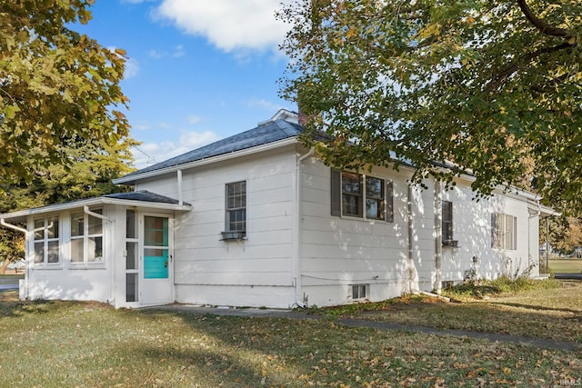 exterior space with a front lawn and a sunroom