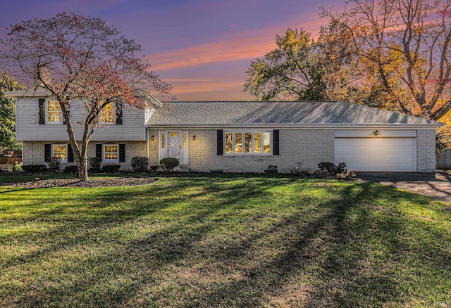 split level home with a garage and a lawn