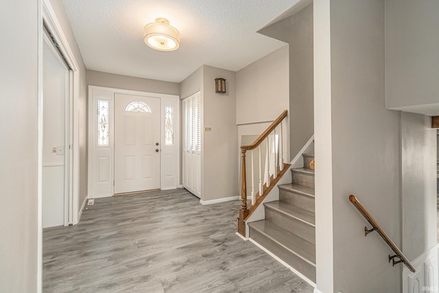 entryway featuring a textured ceiling and light wood-type flooring