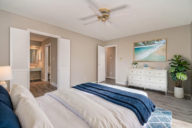 bedroom with ensuite bathroom, hardwood / wood-style flooring, and ceiling fan