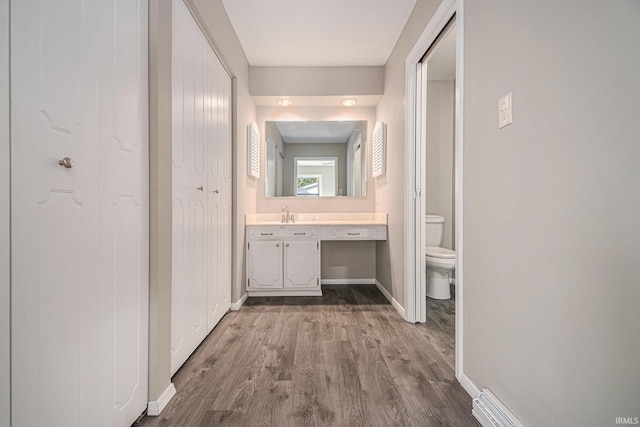 hall with hardwood / wood-style floors and sink