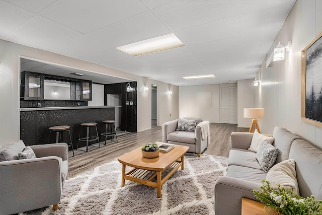 living room with bar and wood-type flooring