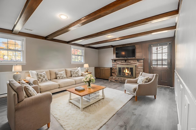 living room with hardwood / wood-style flooring, a healthy amount of sunlight, and a brick fireplace