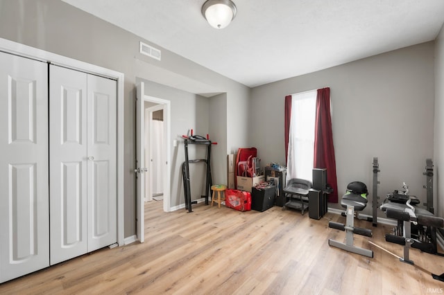 workout room with light hardwood / wood-style floors