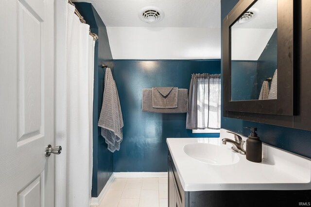 bathroom featuring walk in shower, vanity, and tile patterned floors