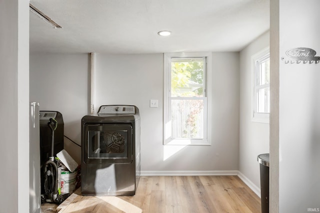 washroom with light hardwood / wood-style flooring and washer and clothes dryer