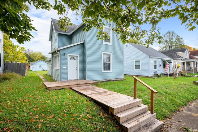 rear view of property featuring a yard and a deck