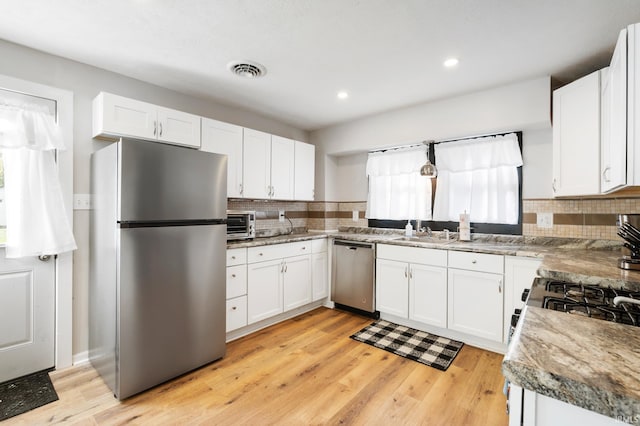 1316 S 19th St, New Castle, IN 47362 - kitchen featuring appliances with stainless steel finishes, backsplash, light wood finished floors, white cabinetry, and recessed lighting