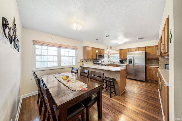 dining room featuring sink, a textured ceiling, and dark hardwood / wood-style flooring