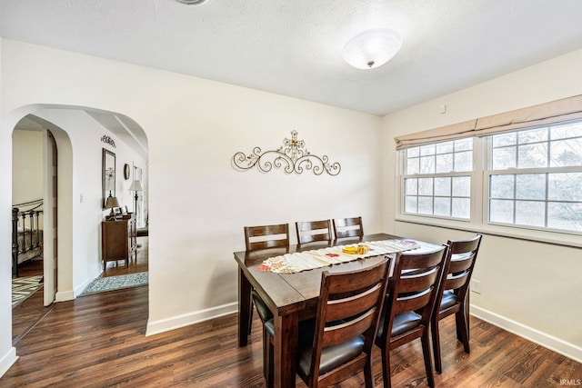 dining space featuring a textured ceiling and dark hardwood / wood-style flooring