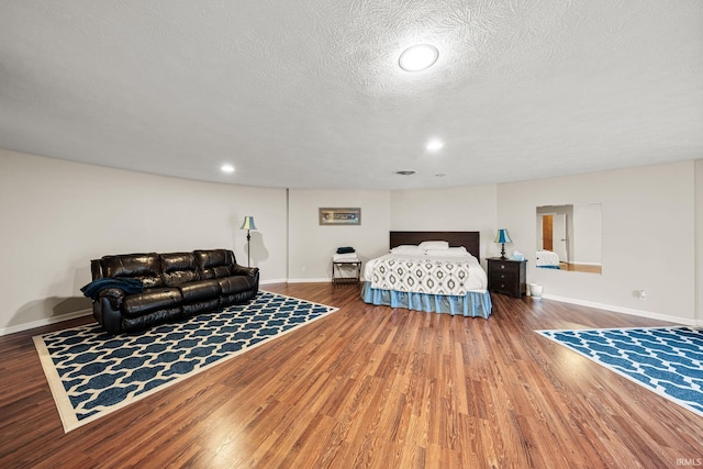 bedroom featuring a textured ceiling and hardwood / wood-style flooring