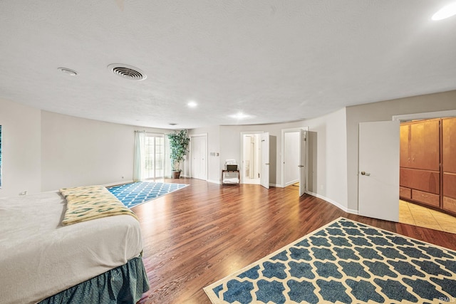 bedroom featuring hardwood / wood-style floors and a textured ceiling