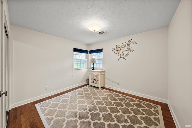 unfurnished bedroom with a textured ceiling and hardwood / wood-style flooring