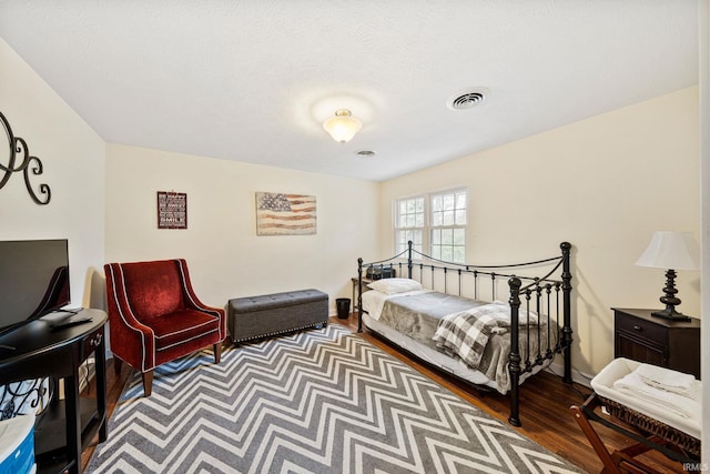 bedroom with a textured ceiling and hardwood / wood-style flooring