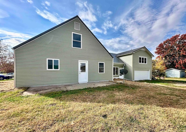 back of property with a yard, an outbuilding, and a garage