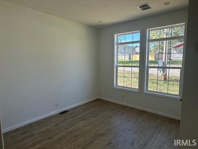 unfurnished room featuring dark hardwood / wood-style flooring