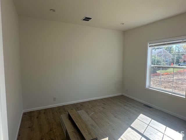 unfurnished room with hardwood / wood-style flooring