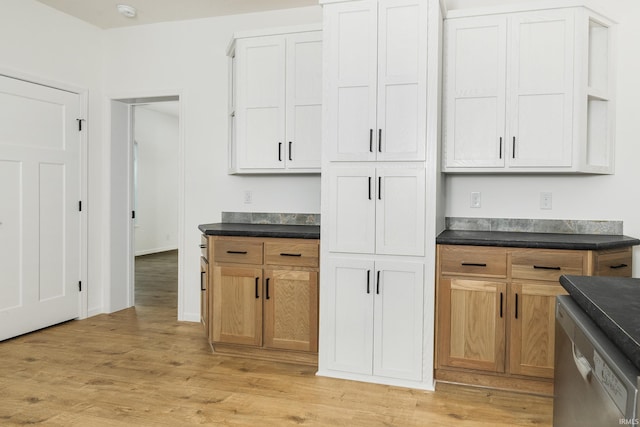 kitchen featuring dark countertops, light wood-type flooring, and dishwasher