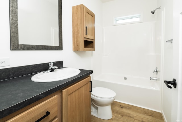 bathroom featuring toilet, bathtub / shower combination, wood finished floors, and vanity