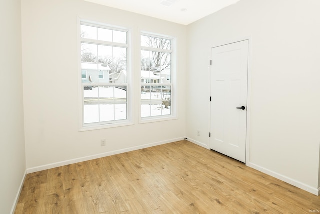 empty room featuring light wood-style floors and baseboards