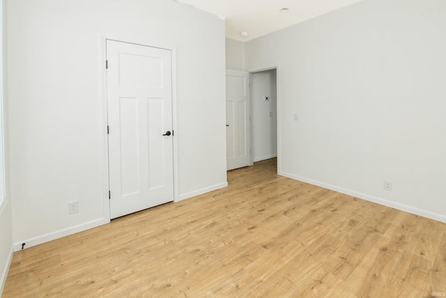 unfurnished bedroom featuring light wood-type flooring and baseboards