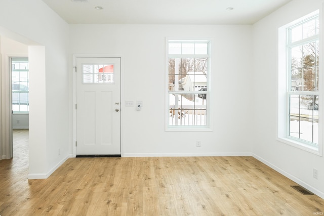 entrance foyer with visible vents, a healthy amount of sunlight, and light wood-style flooring