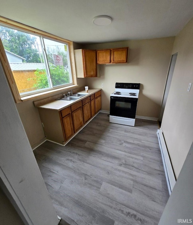 kitchen featuring sink, light hardwood / wood-style flooring, a baseboard heating unit, and electric range