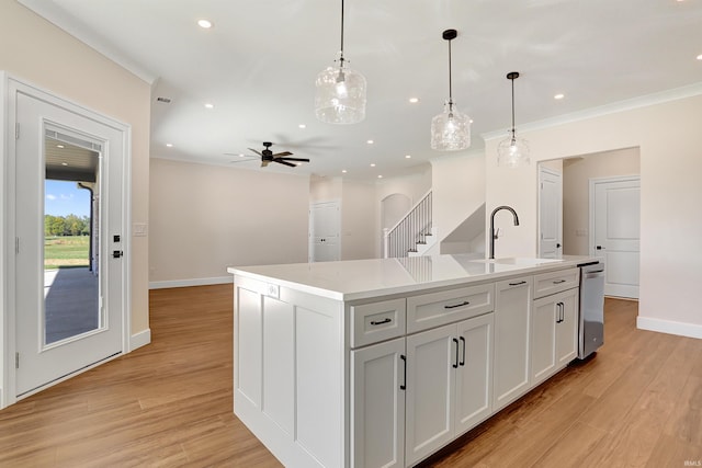 kitchen with a kitchen island with sink, decorative light fixtures, light wood-type flooring, and ceiling fan