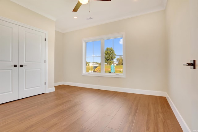 unfurnished bedroom with crown molding, light hardwood / wood-style flooring, a closet, and ceiling fan