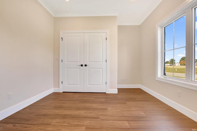 unfurnished bedroom with light hardwood / wood-style flooring and a closet