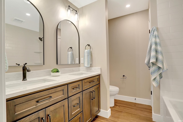 bathroom featuring vanity, toilet, a bathtub, and wood-type flooring