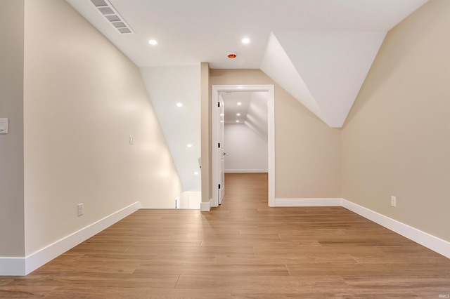 bonus room with lofted ceiling and light wood-type flooring