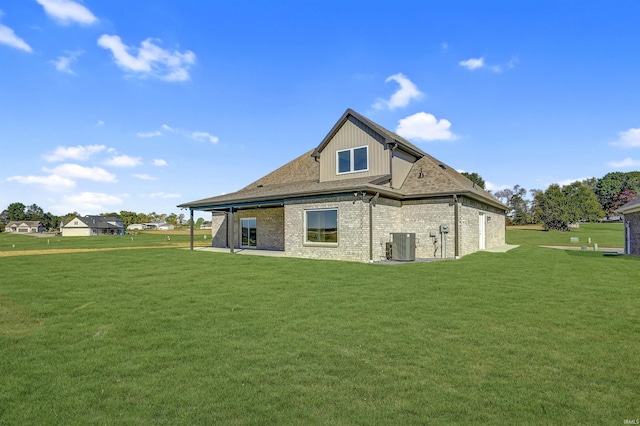 rear view of property featuring a patio, central AC, and a lawn