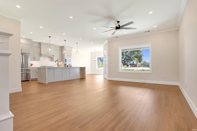 unfurnished living room with ornamental molding, light hardwood / wood-style floors, and ceiling fan