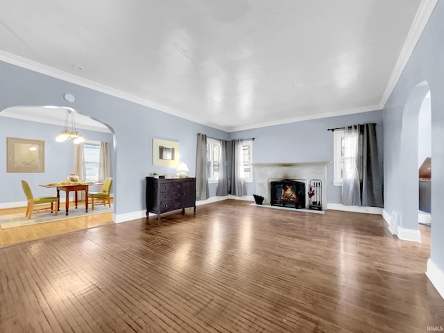 unfurnished living room with ornamental molding, a healthy amount of sunlight, and dark hardwood / wood-style flooring