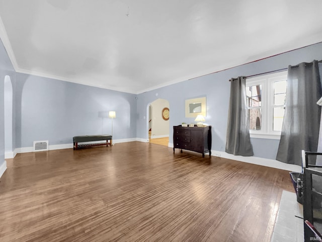 unfurnished living room featuring ornamental molding and hardwood / wood-style floors