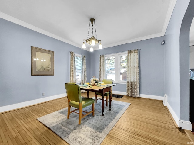 dining space with light hardwood / wood-style floors and crown molding