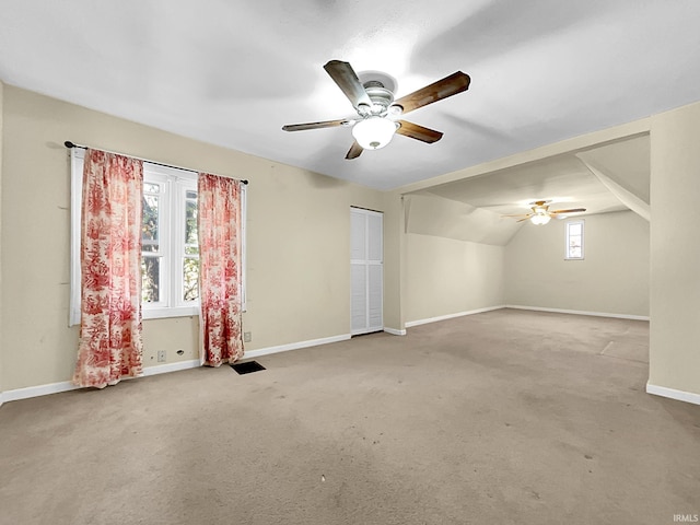 bonus room with lofted ceiling, light colored carpet, and ceiling fan