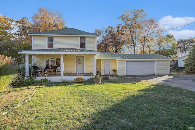 view of front of property featuring a garage, a front lawn, and a porch