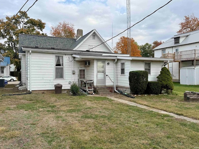 view of front of property with central air condition unit and a front yard